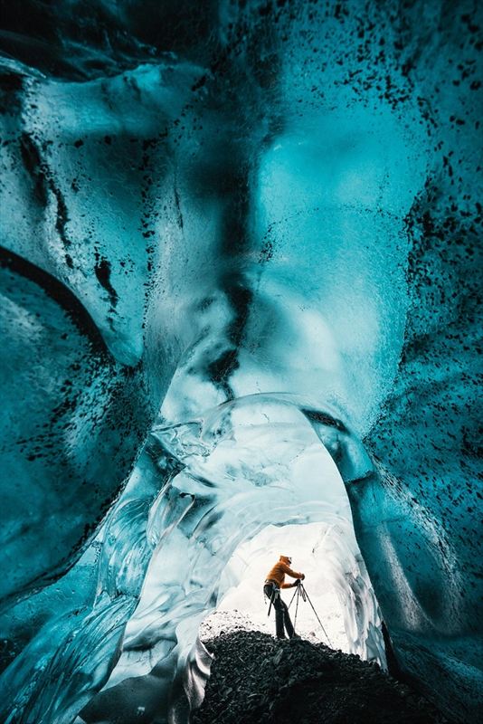 Wednesday 25th November 2015, Vatnajökull national park, Iceland: Photographer Mikael Buck with assistance from renowned local Icelandic guide Einar Runar Sigurdsson, explored the frozen world of Vatnajökull glacier in Iceland using Sony’s world first back-illuminated full-frame sensor – which features in the α7R II camera. His images were taken without use of a tripod or any image stitching techniques in photoshop. This was made possible through Sony’s new sensor technology, allowing incredibly detailed low-light hand held photography. Previously images this detailed would have required carrying bulky equipment to the caves, some of which can require hiking and climbing over a glacier for up to two hours to to access. This picture: Inside the 'ABC cave' - which stands for Amazing Blue Cave.  Guide Einar Runar Sigurdsson is seen taking a photo at the entrance to the cave PR Handout - editorial usage only. Photographer's details not to be removed from metadata or byline. For further information please contact Rochelle Collison at Hope & Glory PR on 020 7014 5306 or rochelle.collison@hopeandglorypr.com Copyright: © Mikael Buck / Sony 07828 201 042 / mikaelbuck@gmail.com