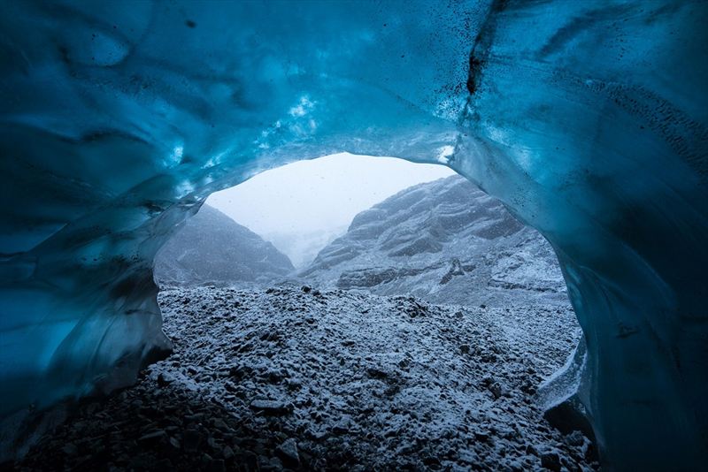 Wednesday 25th November 2015, Vatnajökull national park, Iceland: Photographer Mikael Buck with assistance from renowned local Icelandic guide Einar Runar Sigurdsson, explored the frozen world of Vatnajökull glacier in Iceland using Sony’s world first back-illuminated full-frame sensor – which features in the α7R II camera. His images were taken without use of a tripod or any image stitching techniques in photoshop. This was made possible through Sony’s new sensor technology, allowing incredibly detailed low-light hand held photography. Previously images this detailed would have required carrying bulky equipment to the caves, some of which can require hiking and climbing over a glacier for up to two hours to to access. This picture: Inside the 'ABC cave' - which stands for Amazing Blue Cave. This view shows a snow storm outside the entrance to the cave. PR Handout - editorial usage only. Photographer's details not to be removed from metadata or byline. For further information please contact Rochelle Collison at Hope & Glory PR on 020 7014 5306 or rochelle.collison@hopeandglorypr.com Copyright: © Mikael Buck / Sony 07828 201 042 / mikaelbuck@gmail.com